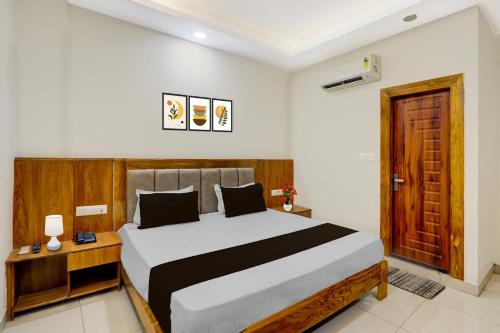 a bedroom with a large bed and a wooden door at Super Townhouse Varanasi City Station Formerly S Kumar Inn in Varanasi