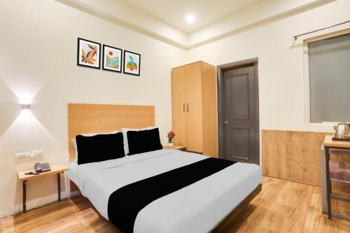a bedroom with a large bed and a television at Super Townhouse Jagatpura Railway Station Formerly Hotel Buddhi in Jaipur