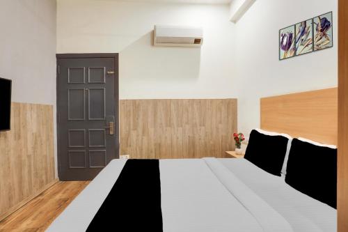 a bedroom with a bed and a black door at Super Townhouse Jagatpura Railway Station Formerly Hotel Buddhi in Jaipur