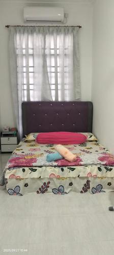 a bedroom with a bed with a purple headboard at Bait al-Qamar in Kampong Wakaf Tengah