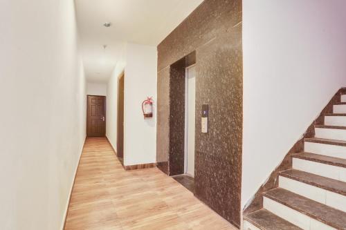 a hallway with stairs in a building with a door at Super Townhouse Jagatpura Railway Station Formerly Hotel Buddhi in Jaipur