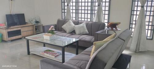 een woonkamer met een bank en een tafel bij Bait al-Qamar in Kampong Wakaf Tengah