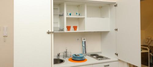una cucina con mobili bianchi e un lavandino di Il Piccolo Principe B&B a Gravina in Puglia