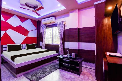 a bedroom with a bed with a colorful wall at Super Collection O New Jalpaiguri Railway Station Formerly Prince Lodge in Siliguri