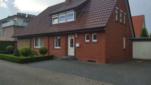 a red brick house with a white door at An der Wilhelmshöhe in Lingen