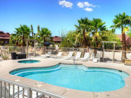 a swimming pool with lounge chairs and a fence at Stagecoach Trails Guest Ranch in Yucca