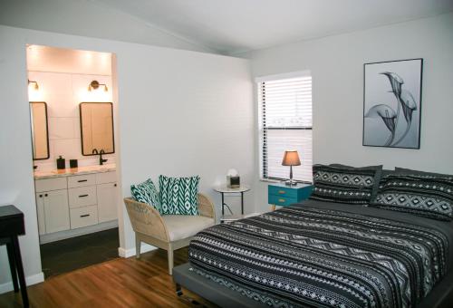 a bedroom with a bed and a bathroom with a sink at Large Pool & Patio Cozy Single Story Family House in Las Vegas