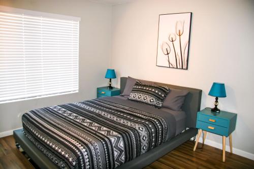 a bedroom with a bed with two blue night stands at Large Pool & Patio Cozy Single Story Family House in Las Vegas