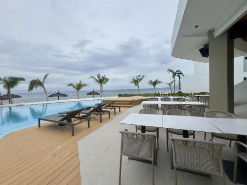 un restaurante con mesas y sillas junto a una piscina en Lime Resort Bohol, en Panglao