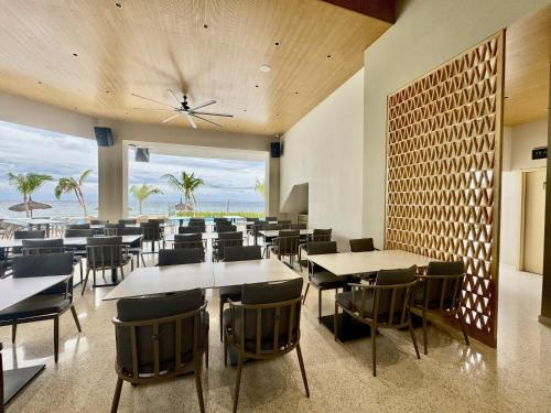 Un restaurante con mesas y sillas y vista al mar. en Lime Resort Bohol, en Panglao