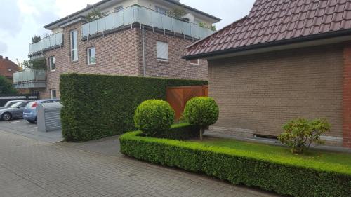 a brick building with bushes in front of a building at An der Wilhelmshöhe in Lingen