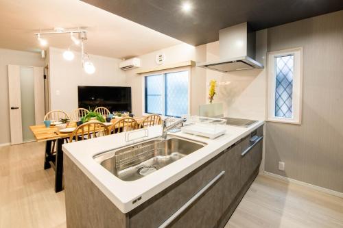 a kitchen with a sink and a dining room at Manpukuya Tanimachi in Osaka