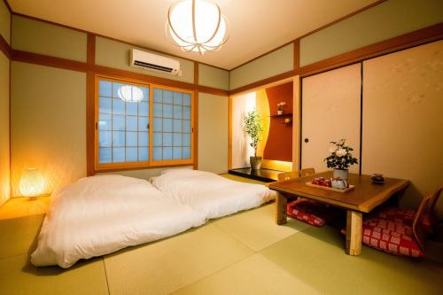 a bedroom with a white bed and a table at Manpukuya Tanimachi in Osaka