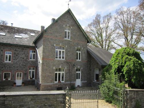 CierreuxにあるBovigny holiday home with cinemaの塀が前に建つ古いレンガ造りの家