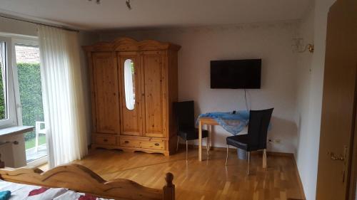 a bedroom with a wooden cabinet and a table and chairs at An der Wilhelmshöhe in Lingen