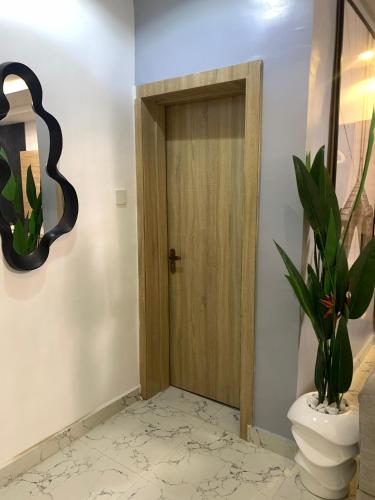 a bathroom with a wooden door and a toilet at Empyrean Apartments - Cozy & warm two bedroom apartments in Lagos