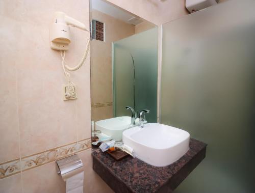 a bathroom with a white sink and a mirror at Milan Hotel & Restaurant in Phnom Penh
