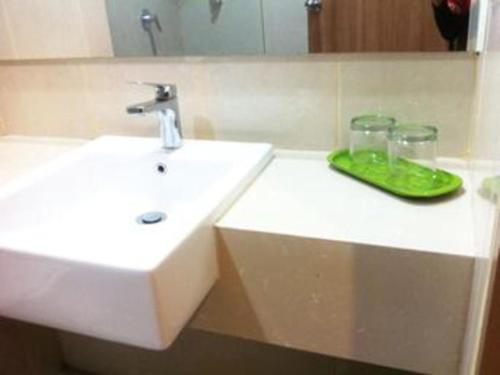 a bathroom with a white sink and a mirror at Evora Hotel in Surabaya