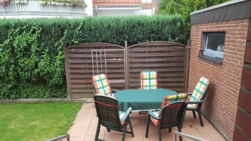 a patio with a table and chairs in a backyard at An der Wilhelmshöhe in Lingen