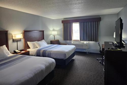 Una habitación de hotel con dos camas y una ventana. en AmericInn by Wyndham Marshall, en Marshall