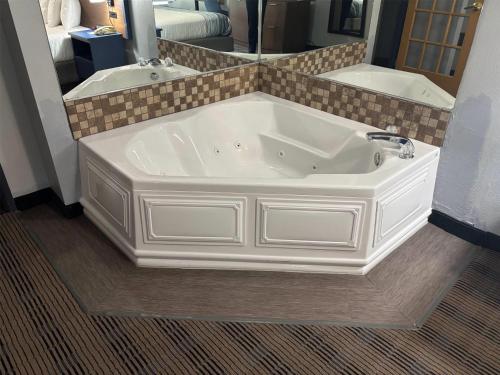 a large white bath tub in a bathroom at AmericInn by Wyndham, Galesburg, IL in Galesburg