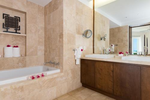 a bathroom with two sinks and a tub and a mirror at West Bay Club in Grace Bay