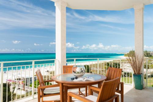 a table and chairs on a balcony with a view of the beach at West Bay Club in Grace Bay