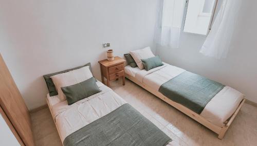 two beds sitting next to each other in a room at Casa de Luz - Beach & Boulevard in Torrevieja