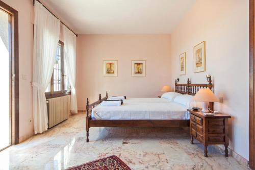 ein Schlafzimmer mit einem Bett und einem Tisch mit einer Lampe in der Unterkunft Casa Costa Blanca in Jávea