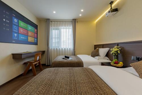 a hotel room with two beds and a large screen at Zemulong Inn - Shangri-La, Dukezong Ancient Town, Moonlight Plaza in Shangri-La