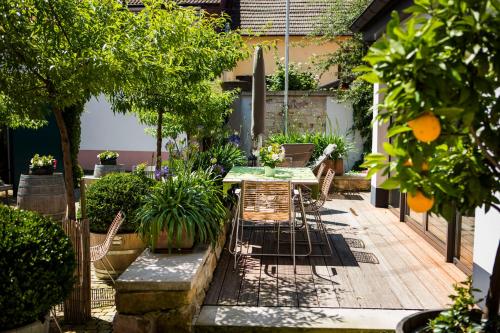 a patio with a table and chairs and trees at Loblocher Hof in Neustadt an der Weinstraße