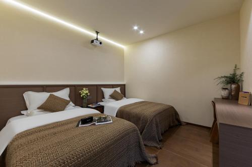 a hotel room with two beds and a table at Zemulong Inn - Shangri-La, Dukezong Ancient Town, Moonlight Plaza in Shangri-La