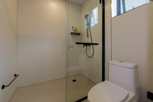 a white bathroom with a shower and a toilet at Zemulong Inn - Shangri-La, Dukezong Ancient Town, Moonlight Plaza in Shangri-La