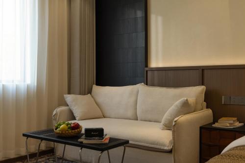 a living room with a couch and a table with a bowl of fruit at Zemulong Inn - Shangri-La, Dukezong Ancient Town, Moonlight Plaza in Shangri-La