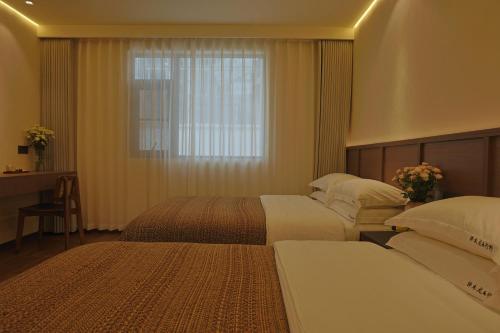 a hotel room with two beds and a window at Zemulong Inn - Shangri-La, Dukezong Ancient Town, Moonlight Plaza in Shangri-La