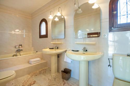 ein Badezimmer mit zwei Waschbecken und einer Badewanne und einer Toilette in der Unterkunft Casa Costa Blanca in Jávea