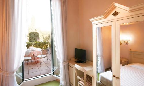 a bedroom with a bed and a balcony with a table at Hotel Settentrionale Esplanade in Montecatini Terme