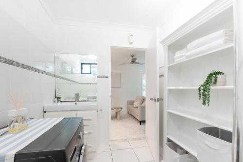Cairns NorthにあるCosy Stay near Cairns Esplanadeの洗面台と鏡のある白いバスルーム