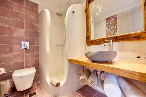 a bathroom with a toilet and a sink and a mirror at Ibiscus Boutique in Mýkonos City