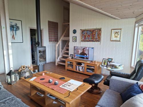 ein Wohnzimmer mit Sofa und Tisch in der Unterkunft Moderne hytte på Tingvoll nær sjø og turterreng in Tingvoll