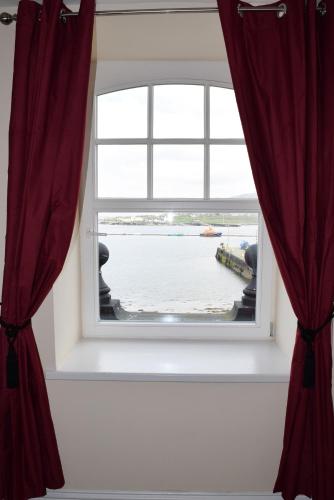 a window with red curtains in a room at Royal Valentia Hotel in Valentia Island