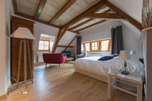a bedroom with a bed and a desk and a chair at La Maison d'Emilie in Pfaffenheim