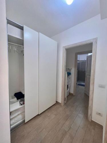 an empty room with white walls and wooden floors at Appartamento Sardinia Escape in residence - Palau in Palau