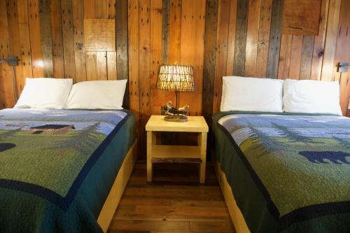 two beds in a room with a lamp on a table at Tamarack Lodge Motel in Tahoe City