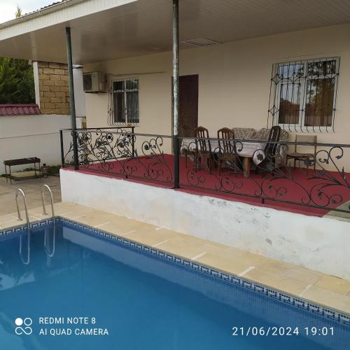 una casa con piscina con sedie e balcone di Gabala,yard, house a Gabala