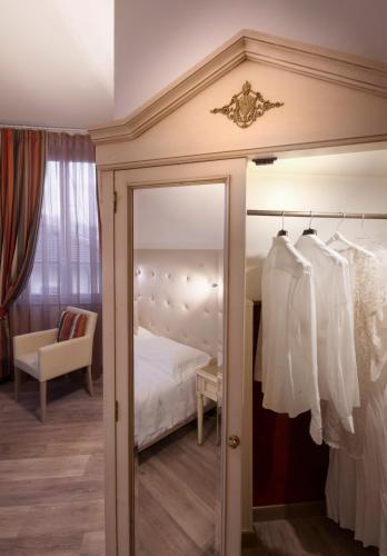 a bedroom with a bed and a mirror at Hotel Settentrionale Esplanade in Montecatini Terme