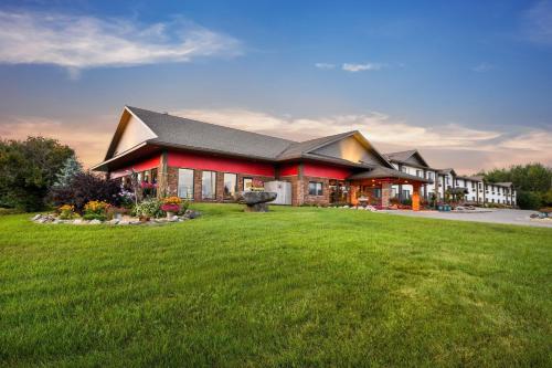 a large building with a large lawn in front of it at Super 8 by Wyndham Eveleth in Eveleth