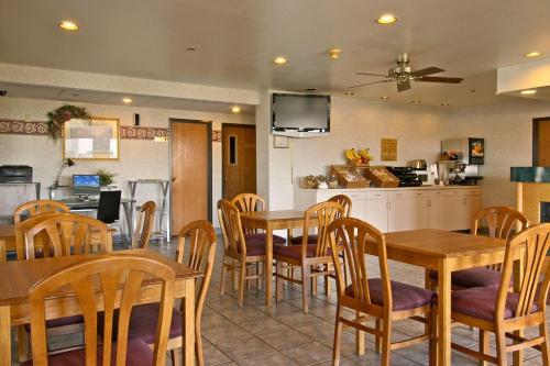 a dining room with wooden tables and chairs at Baymont by Wyndham Tuscola in Tuscola