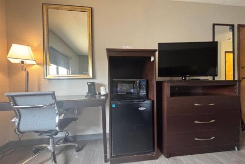a hotel room with a desk with a television and a computer at Baymont by Wyndham Tuscola in Tuscola