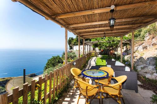 a patio with a table and chairs and the ocean at Fico D'India Relais in Furore